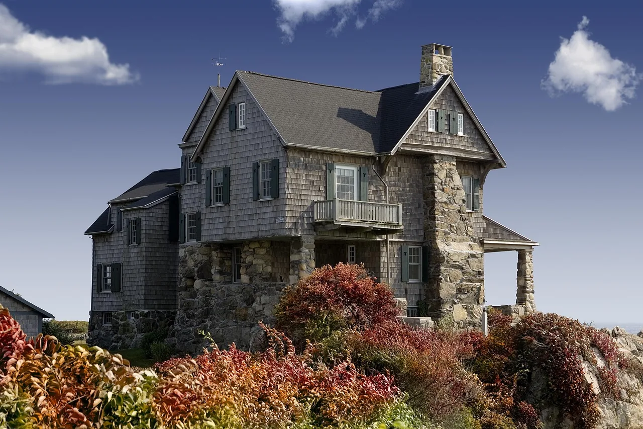 Older stone-and-shingle home with a steep multi-gable roof
